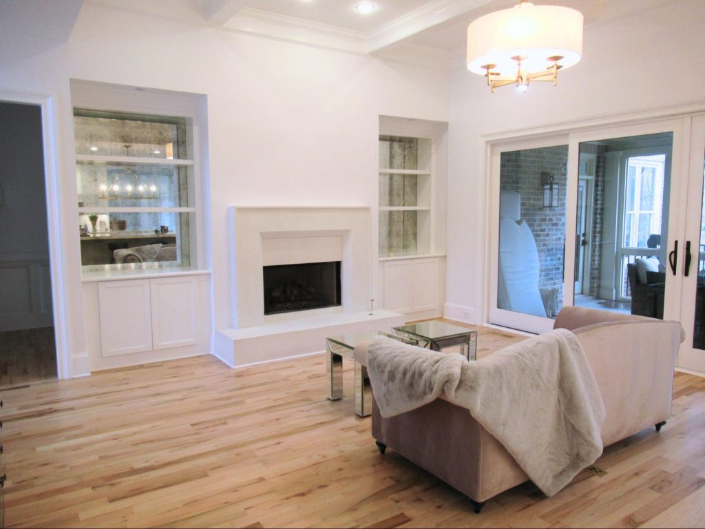 Modern gas fireplace with white stone surround and cozy furniture.