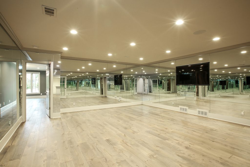 Finished basement remodel fitness studio with mirrored walls and open-concept layout.