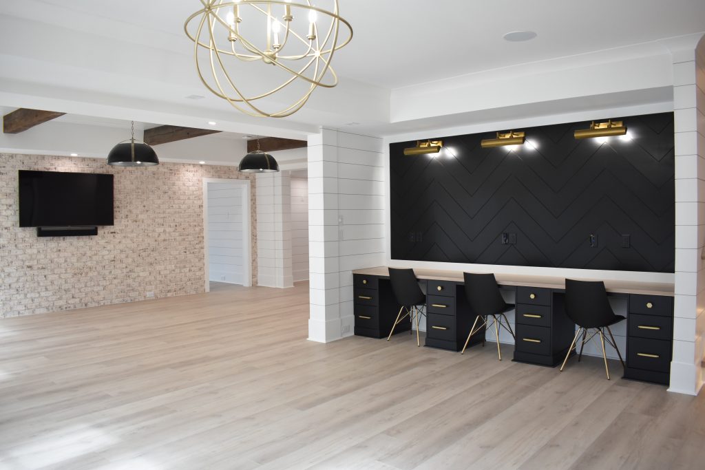 Custom basement remodel featuring a multi-user home office with black cabinetry and gold hardware. Show less