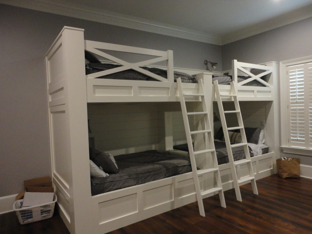 Functional basement remodel guest bedroom with custom-built white bunk beds for hosting.