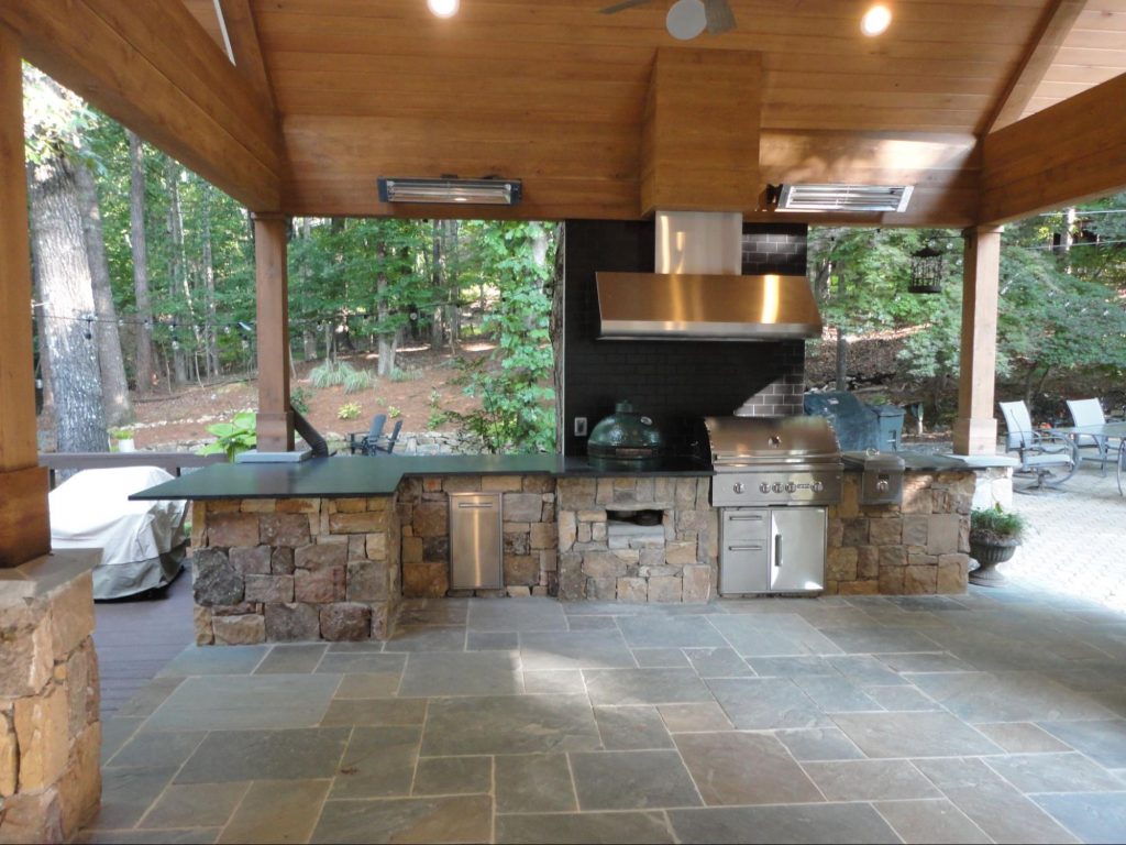 Stone outdoor kitchen with lots of counter space and a built-in grill